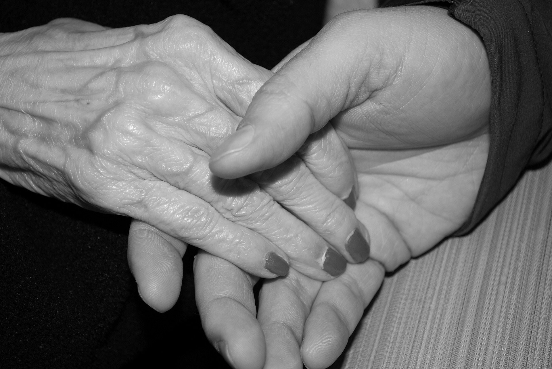an image of a hand holding the hand of an elderly woman